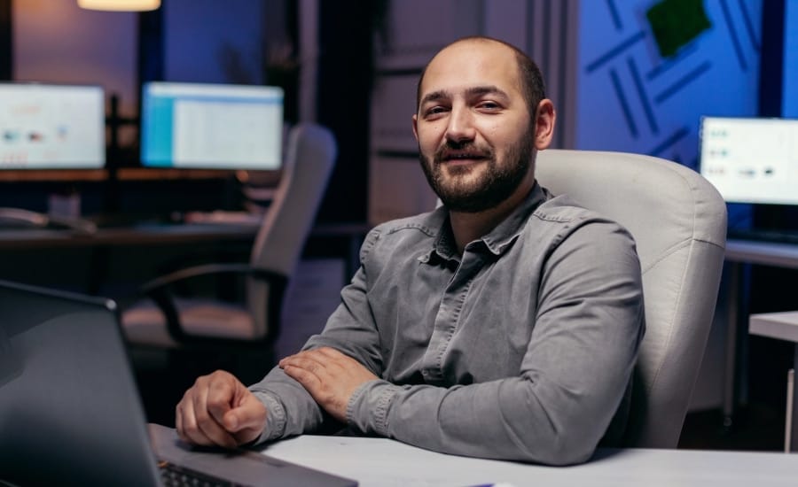 homem em escritorio olhando confiante