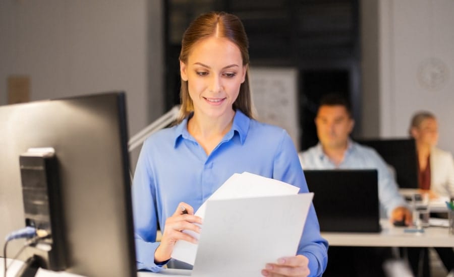 mulher analisando documentos de papel em um escritório