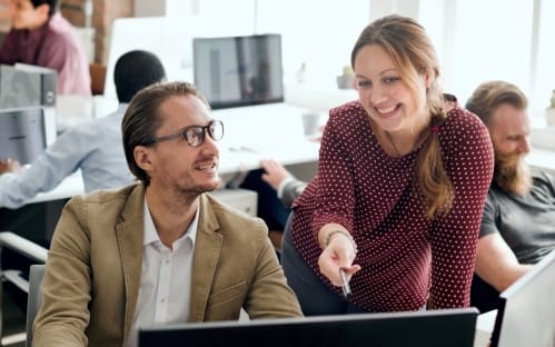 mulher explicando a homem em um computador