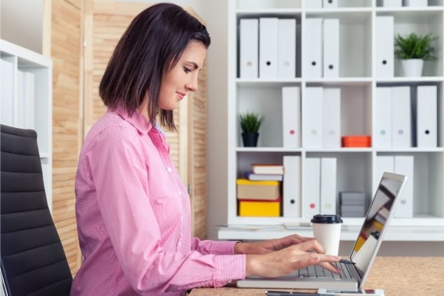 mulher trabalhando em um notebook dentro de um escritório